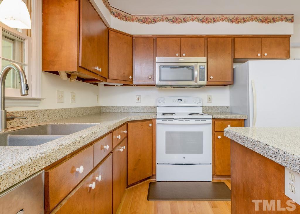 215 Lawrence Road Cary, NC 27511 - Photo 13 of 28 a kitchen with stainless steel appliances granite countertop a sink stove and microwave