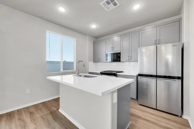 a kitchen with stainless steel appliances a refrigerator sink and microwave