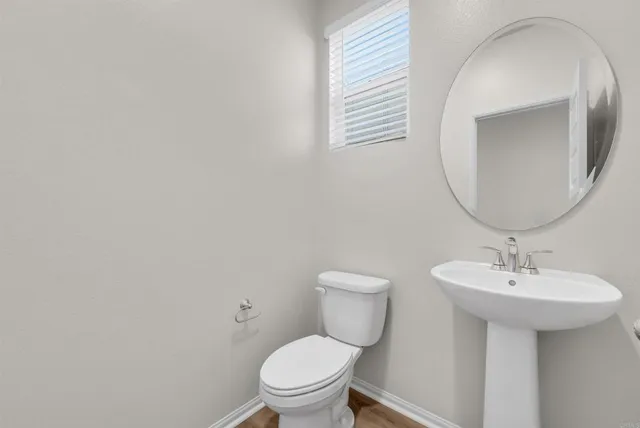 a bathroom with a sink a toilet and mirror