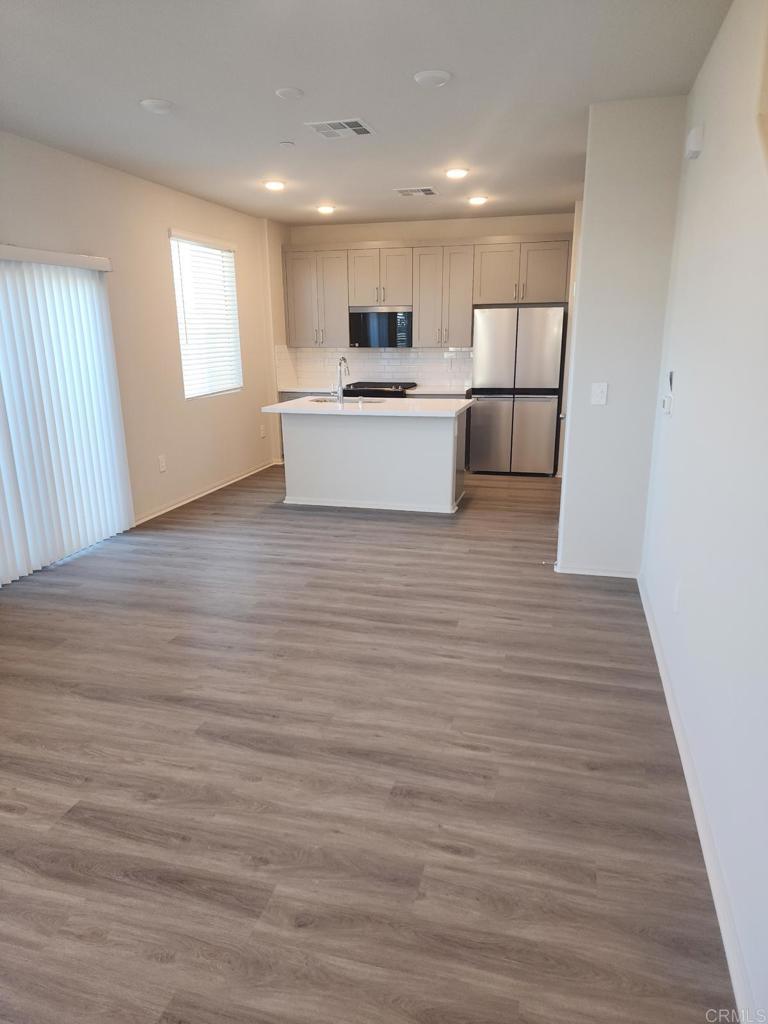 28386 Via Solero Temecula, CA 92591 - Photo 3 of 17 a view of a kitchen with wooden floor and electronic appliances