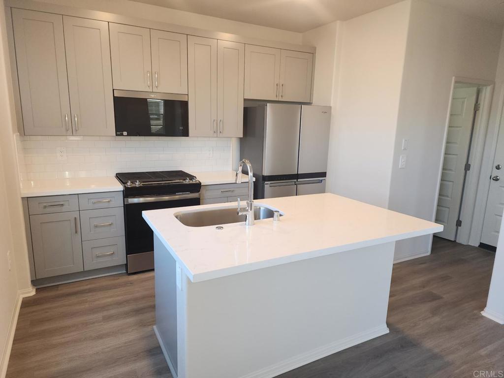 28386 Via Solero Temecula, CA 92591 - Photo 5 of 17 a kitchen with stainless steel appliances a sink a stove a microwave a refrigerator and cabinets