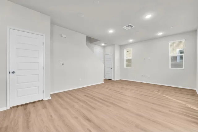 a view of an empty room with closet and a window