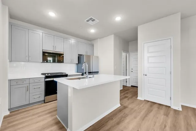 a kitchen with cabinets and stainless steel appliances
