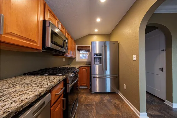 a kitchen with granite countertop stainless steel appliances and wooden cabinets
