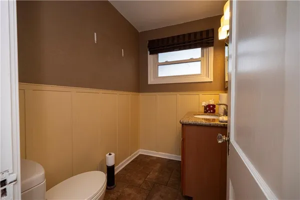 a bathroom with a granite countertop toilet and sink