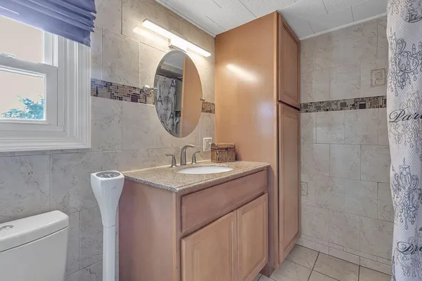 a bathroom with a toilet sink and mirror