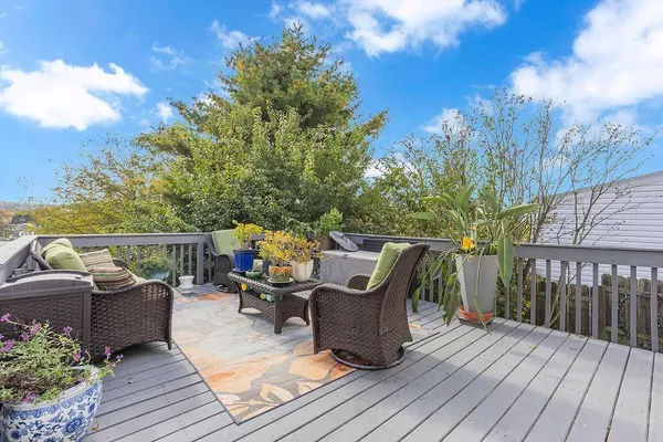 a view of a deck with couches table and chairs with wooden floor