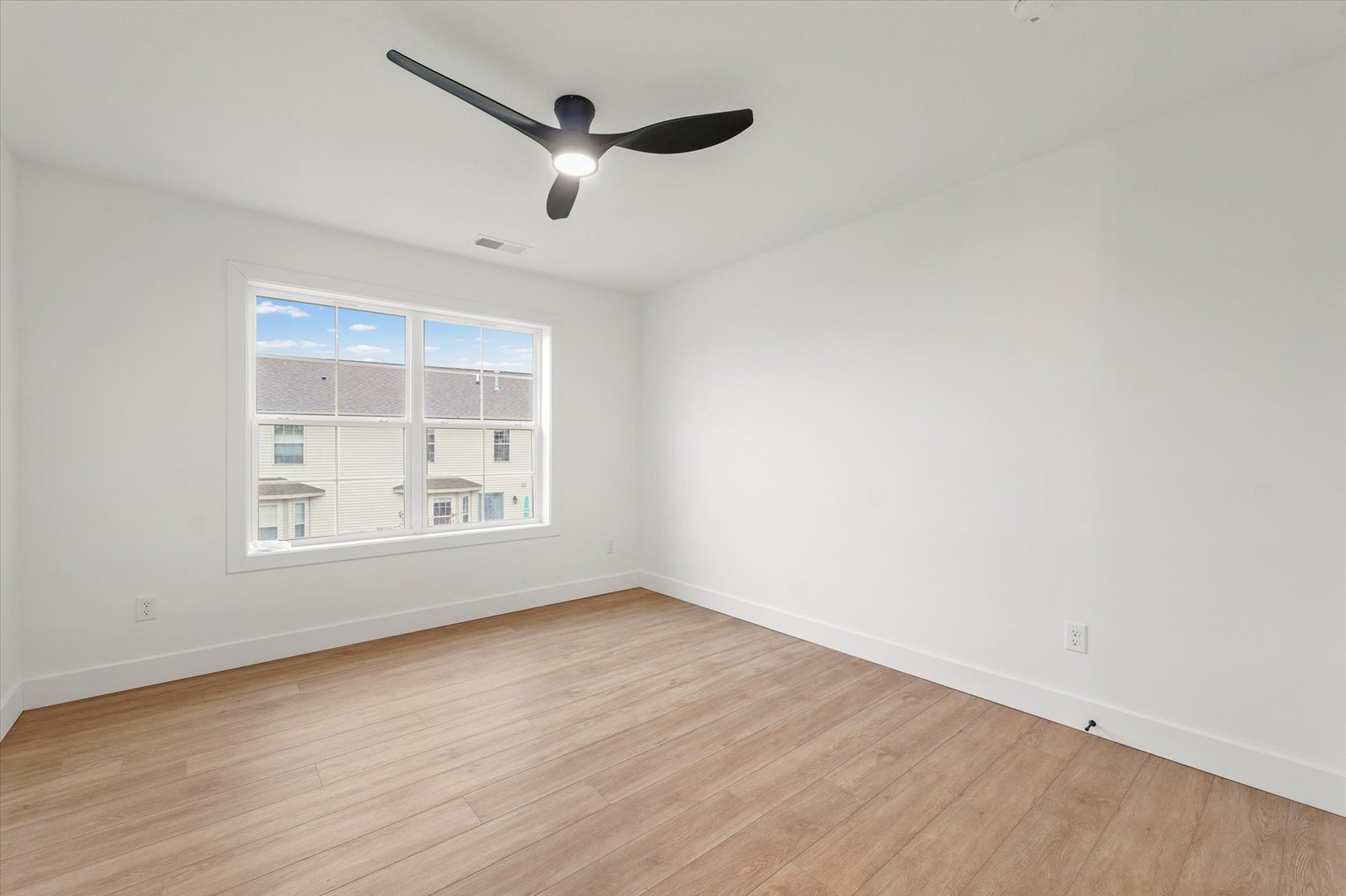 3708 Lighthouse Pointe Champaign, IL 61822 - Photo 26 of 35 an empty room with wooden floor chandelier fan and windows