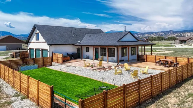 a view of a house with pool and chairs