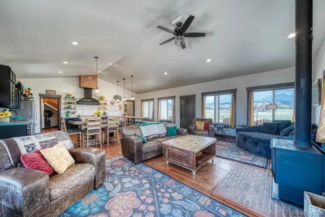 a living room with furniture kitchen view and a large window