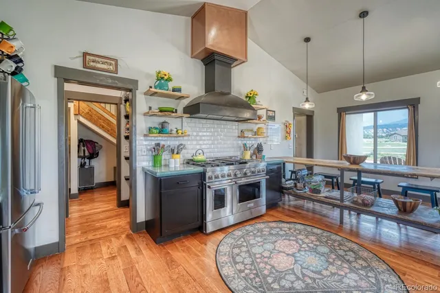 a kitchen with stainless steel appliances granite countertop a stove a sink and a refrigerator