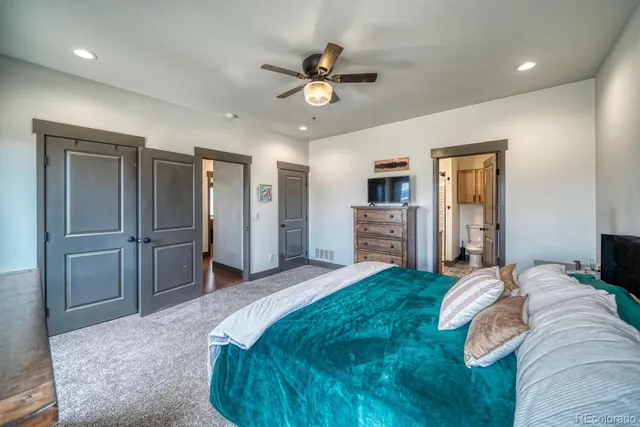 a spacious bedroom with a bed and a chandelier