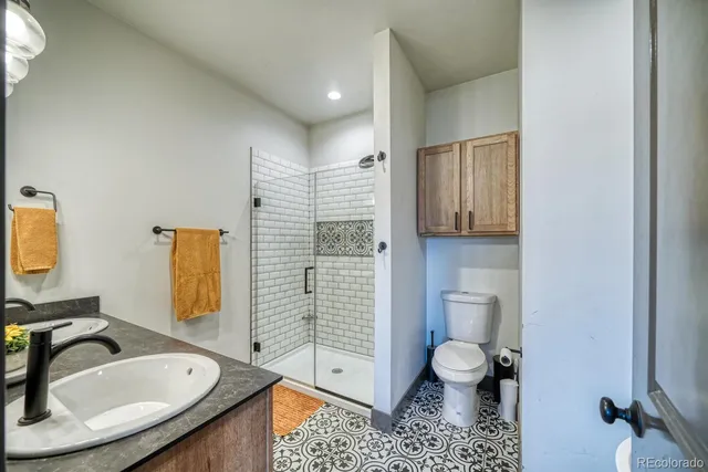 a bathroom with a sink a toilet and shower