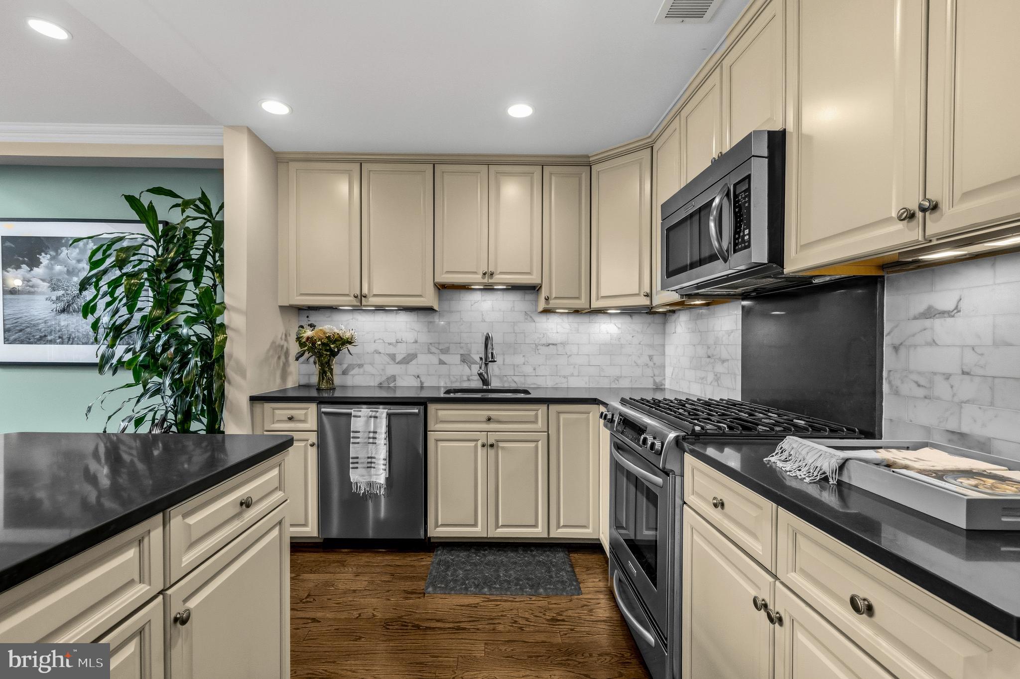 1232 4th Street Northwest, Unit 1 Washington, DC 20001 - Photo 6 of 28 a kitchen with granite countertop a sink a stove and cabinets