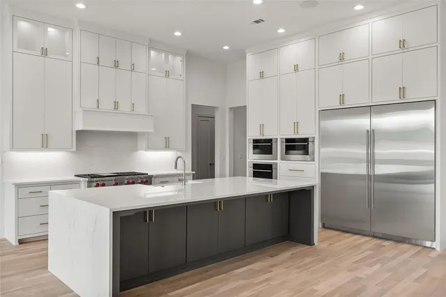 a kitchen with kitchen island cabinets and stainless steel appliances