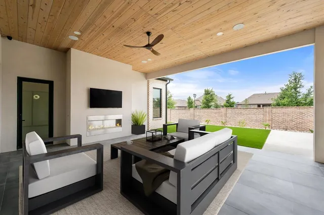 a living room with patio furniture and a floor to ceiling window