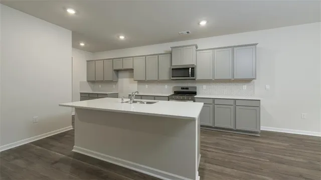 a kitchen with kitchen island white cabinets appliances and a sink