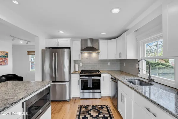 a kitchen with granite countertop kitchen island stainless steel appliances a refrigerator a stove a microwave and cabinets