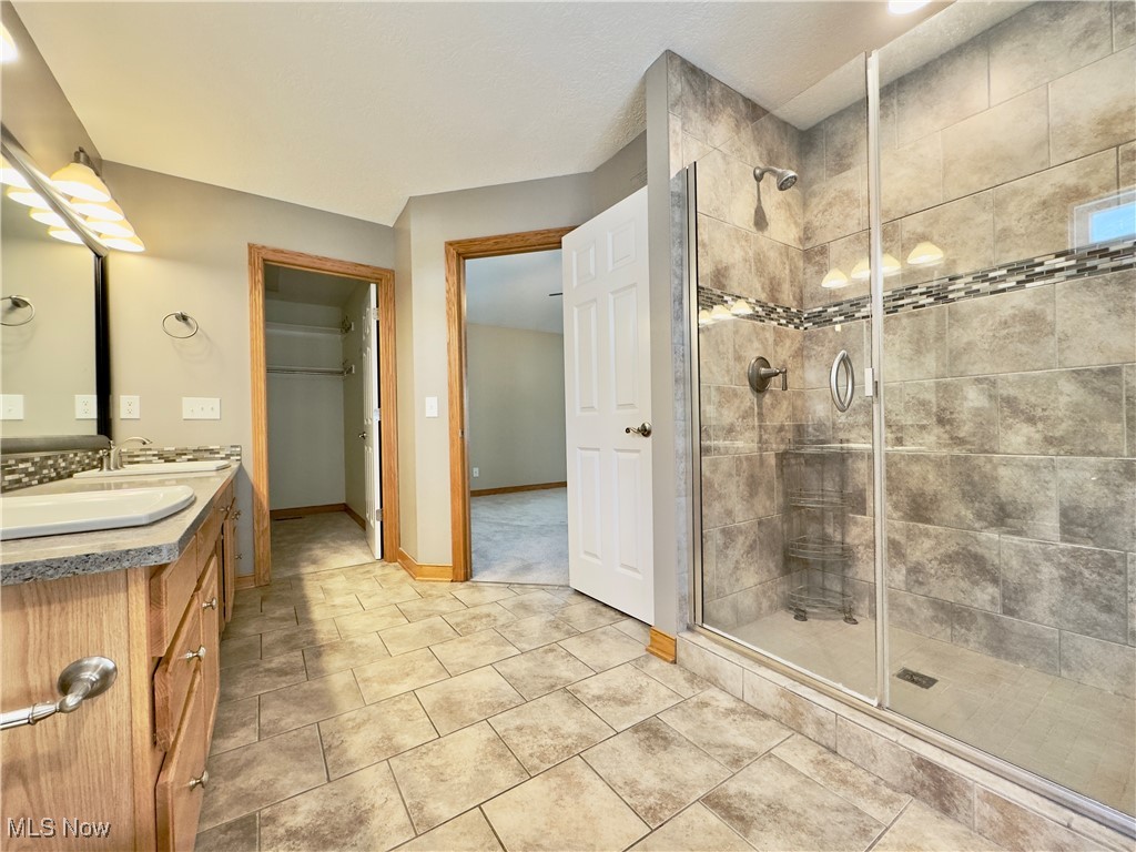 6014 Wentworth Road Southwest Canton, OH 44706 - Photo 12 of 22 Primary bathroom with double vanity, a stall shower, tile floors, and walk-in closet