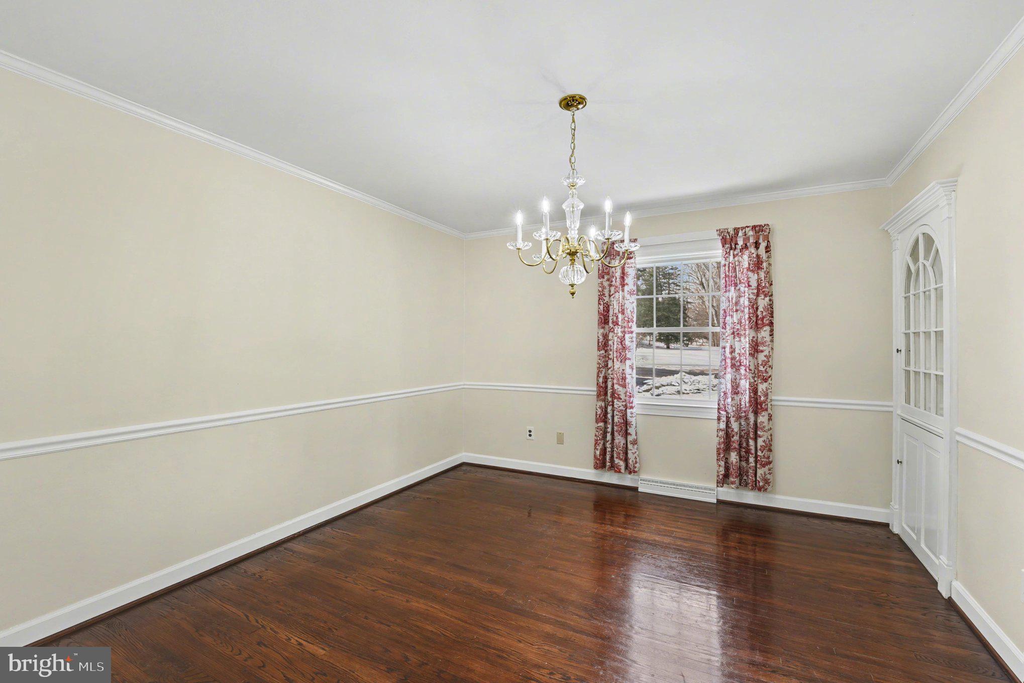 1411 Valley Stream Road Bel Air, MD 21014 - Photo 18 of 49 an empty room with wooden floor chandelier and windows