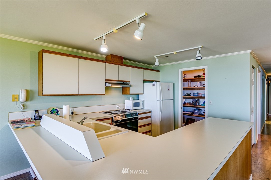 226 West 2nd Street, Unit 2 Port Angeles, WA 98362 - Photo 20 of 40 a kitchen with stainless steel appliances a refrigerator a sink a stove and white cabinets