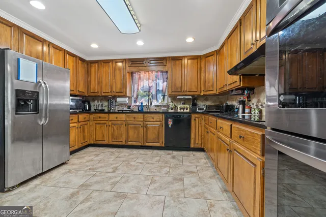 a kitchen with stainless steel appliances a refrigerator sink and cabinets