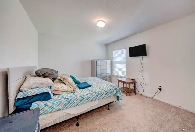 a bedroom with a bed and a flat screen tv