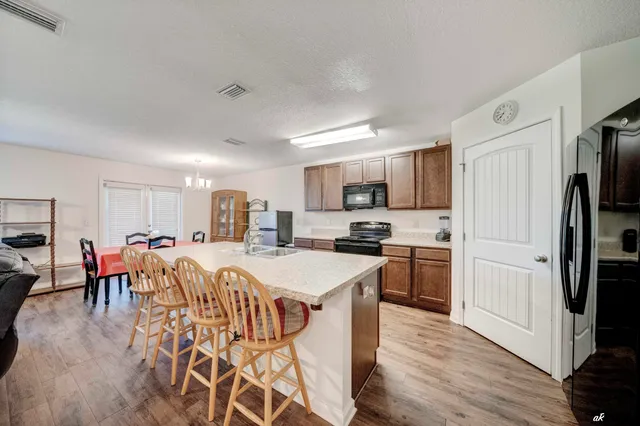 a large kitchen with a lot of cabinets a sink a window and stainless steel appliances