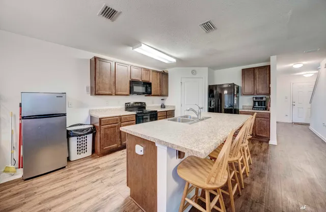 a kitchen with kitchen island a refrigerator stove and microwave