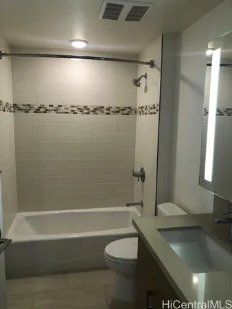 a bathroom with a granite countertop bathtub shower sink vanity and toilet
