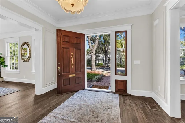 a view of an empty room with wooden floor and stairs