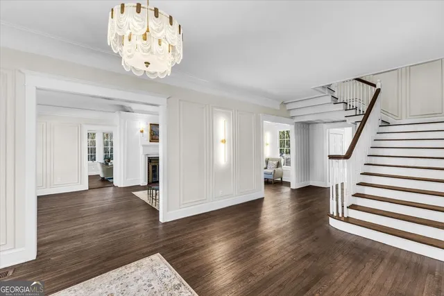 a view of a hallway with wooden floor and a bathroom