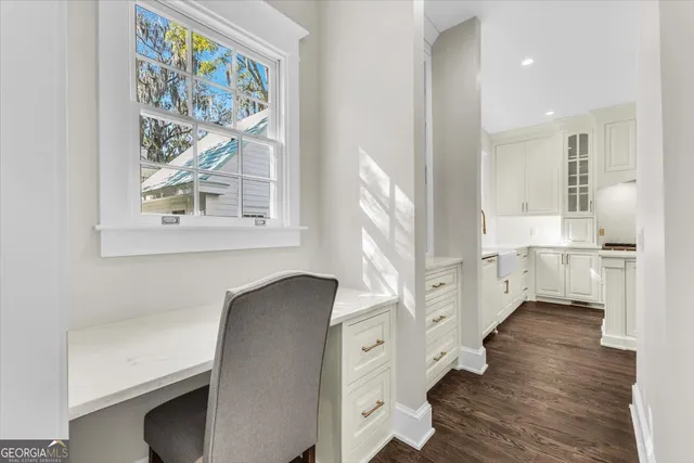 a kitchen with stainless steel appliances granite countertop a sink a stove a refrigerator and white cabinets with wooden floor