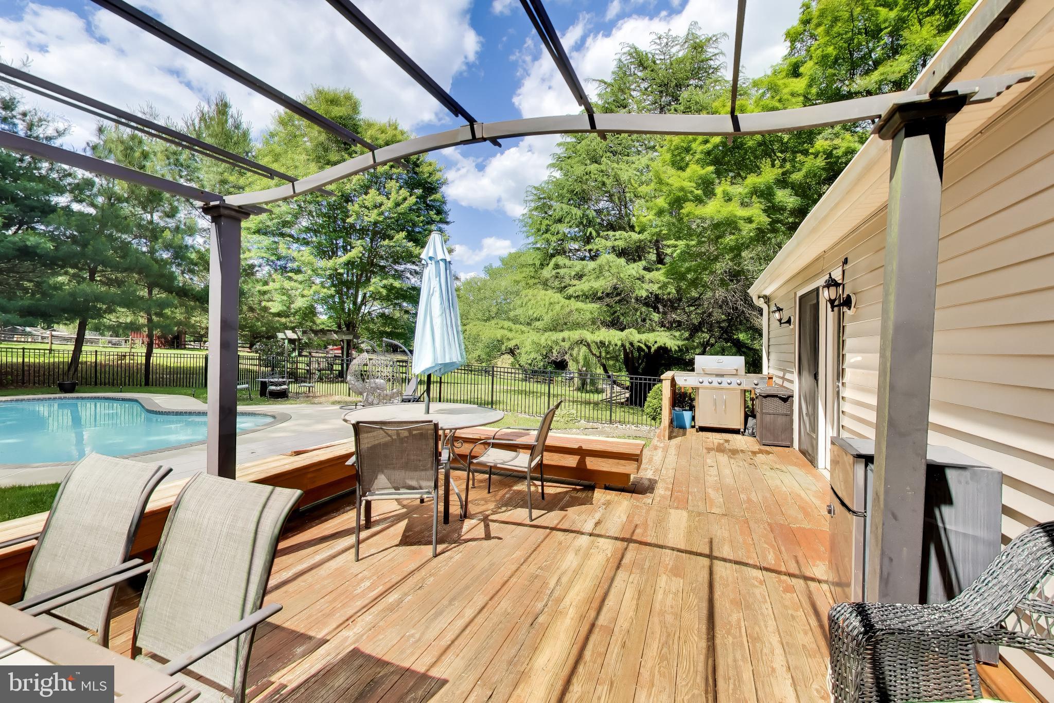 3240 Juniper Lane Huntingtown, MD 20639 - Photo 21 of 48 a view of a patio with table and chairs potted plants with wooden floor and fence