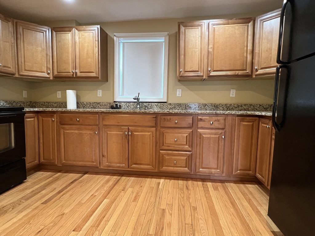 a view of a kitchen with granite countertop wooden cabinets a sink and dishwasher