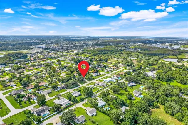 an aerial view of a residential houses with yard