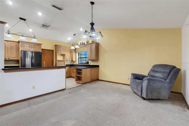 a living room with couches and kitchen view