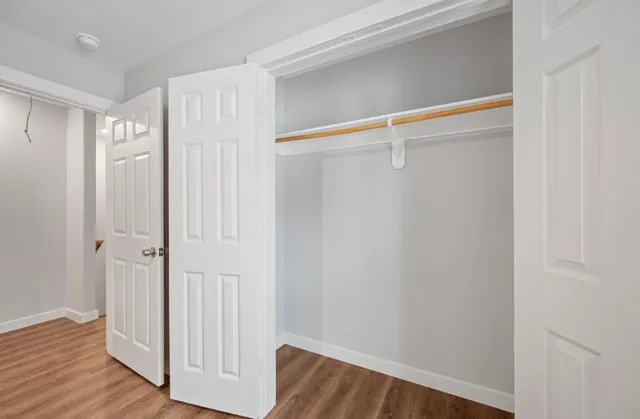 a view of walk in closet with wooden floor