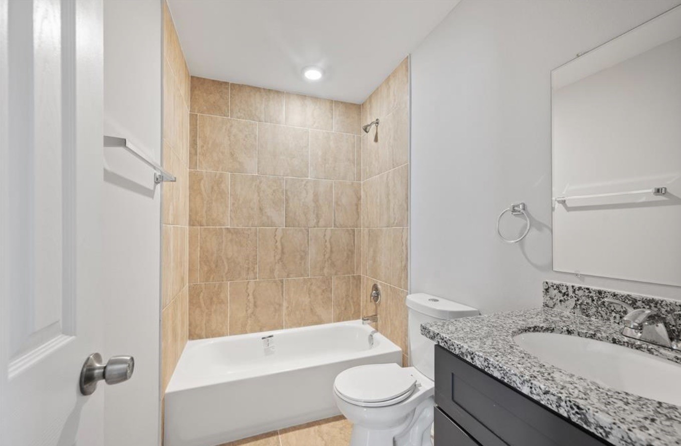 6617 Bacher Street, Unit B Houston, TX 77028 - Photo 20 of 25 a bathroom with a granite countertop sink a toilet and shower