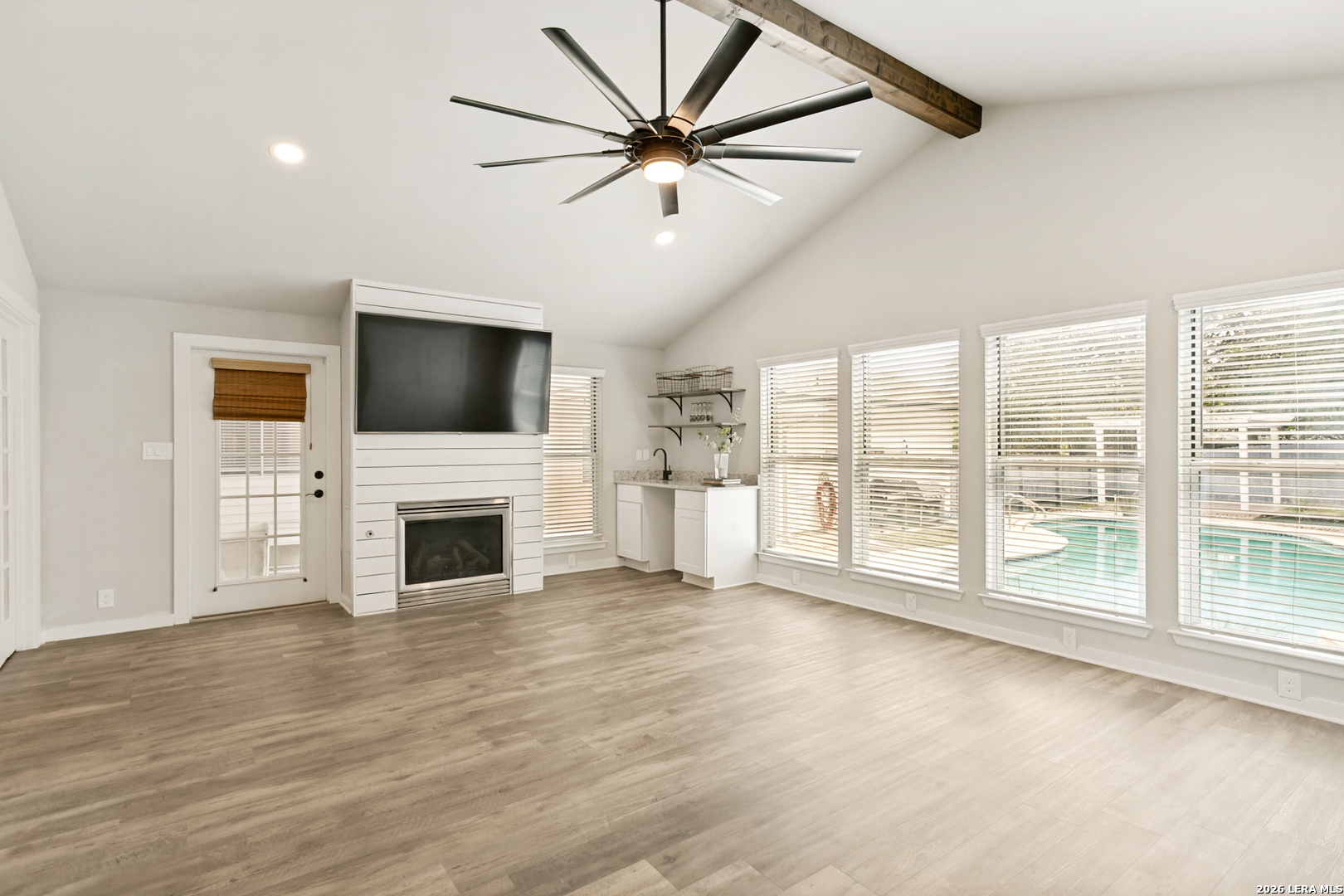 102 Silver Spring Universal City, TX 78148 - Photo 17 of 36 a view of a livingroom with a fireplace a ceiling fan and wooden floor