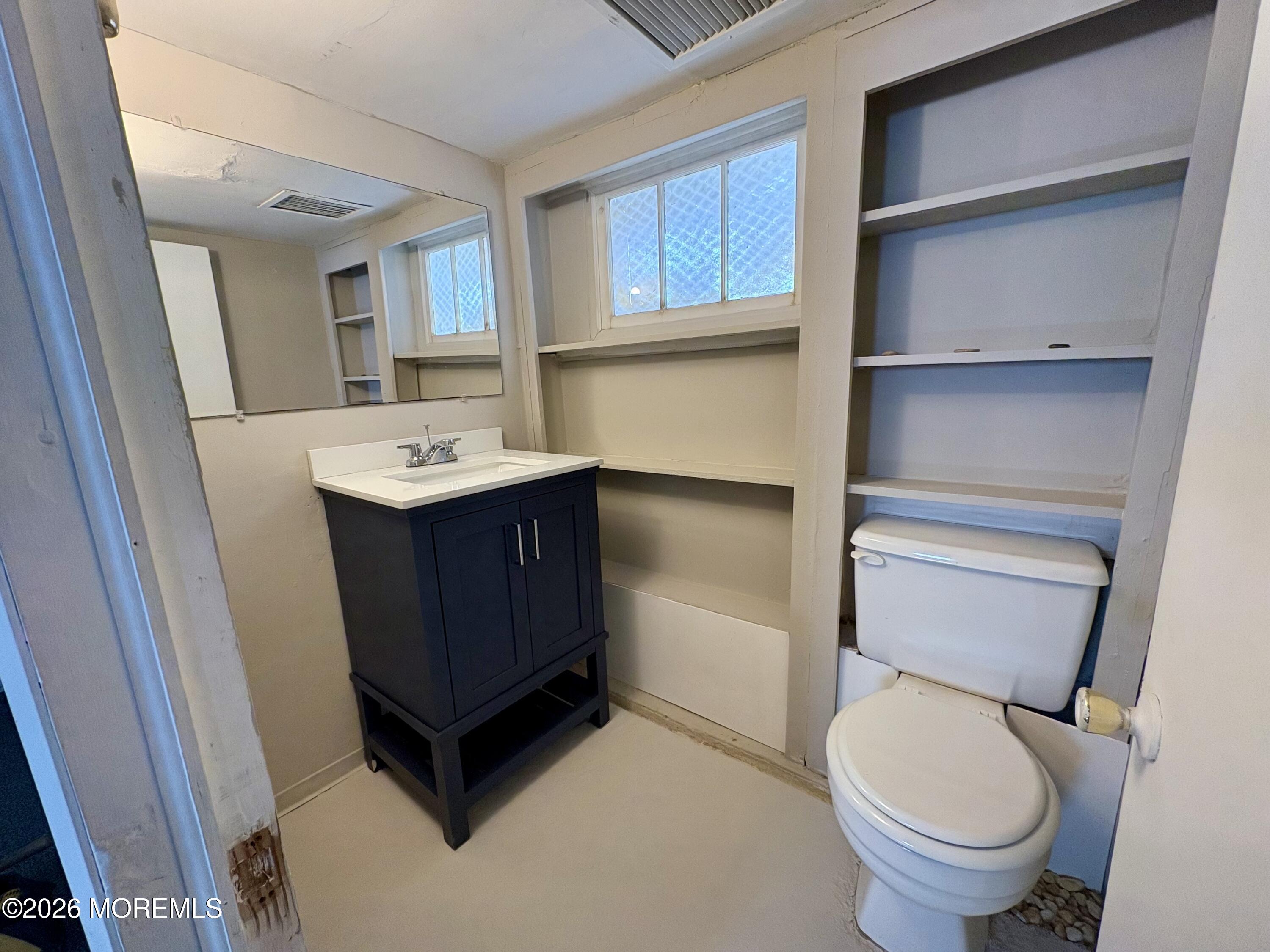 1236 Maplewood Road Belmar, NJ 07719 - Photo 29 of 44 a bathroom with a toilet a sink and a mirror