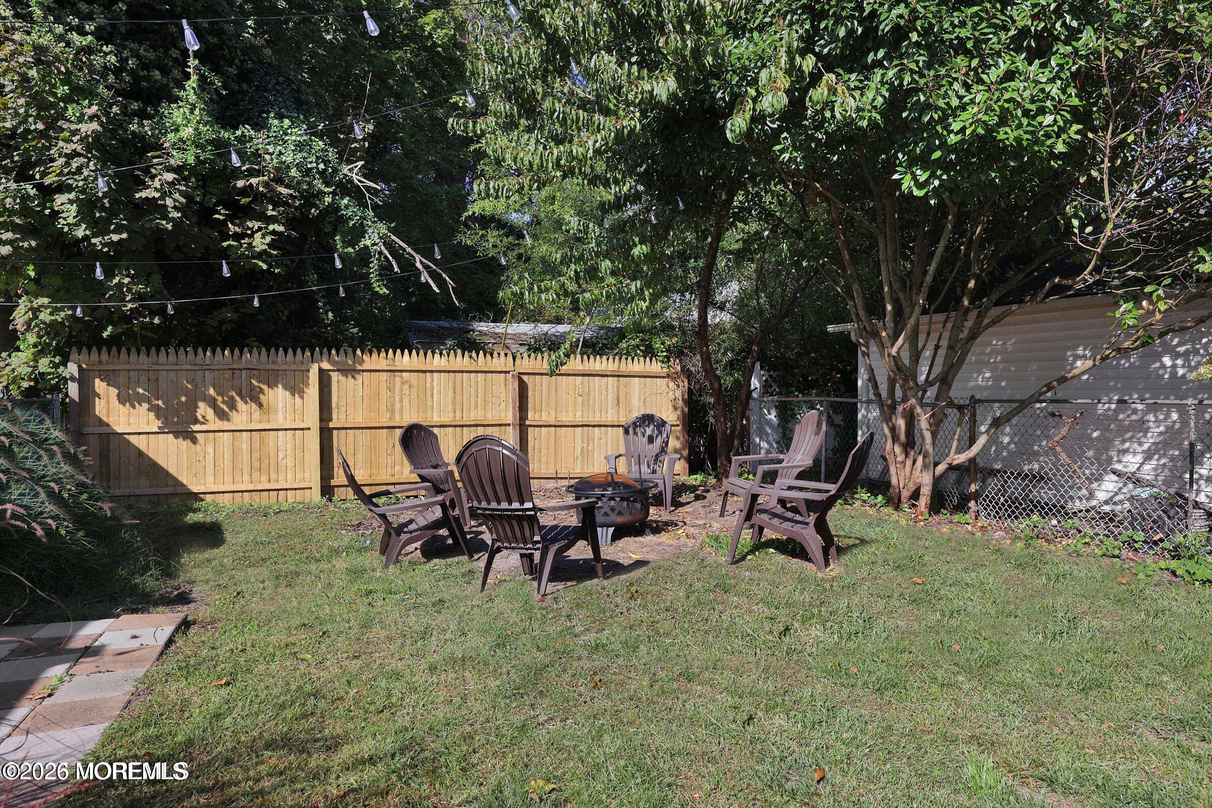 1236 Maplewood Road Belmar, NJ 07719 - Photo 39 of 44 a backyard of a house with table and chairs