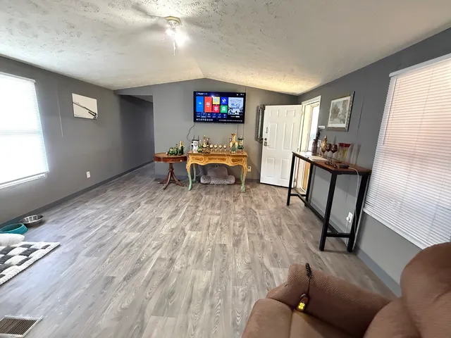 a living room with furniture and a wooden floor