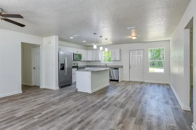 a view of kitchen with refrigerator stove microwave and cabinets