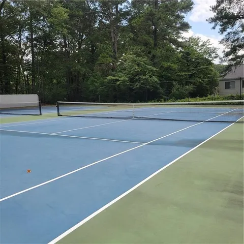 a view of a swimming pool with lawn chairs under an umbrella