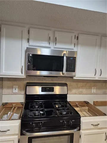 a stove top oven sitting inside of a kitchen