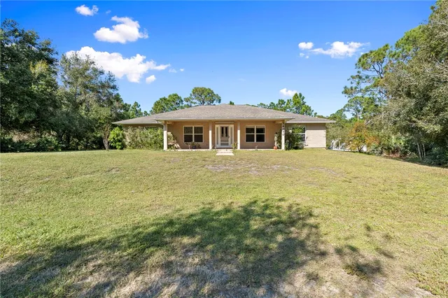 a view of a house with a yard and potted plants