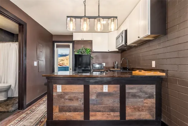 a kitchen view with granite countertop a sink a stove and a wooden floors