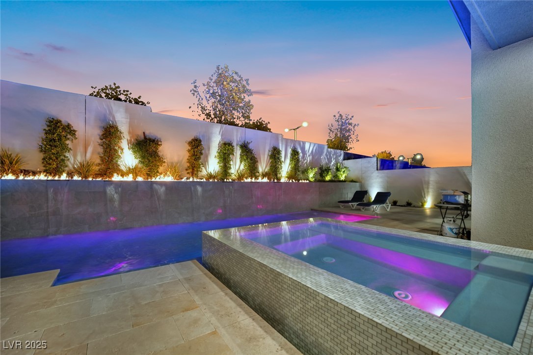 397 Highview Rdg Avenue Las Vegas, NV 89138 - Photo 20 of 97 Pool at dusk with an in-ground hot tub, a patio area, and a fenced backyard