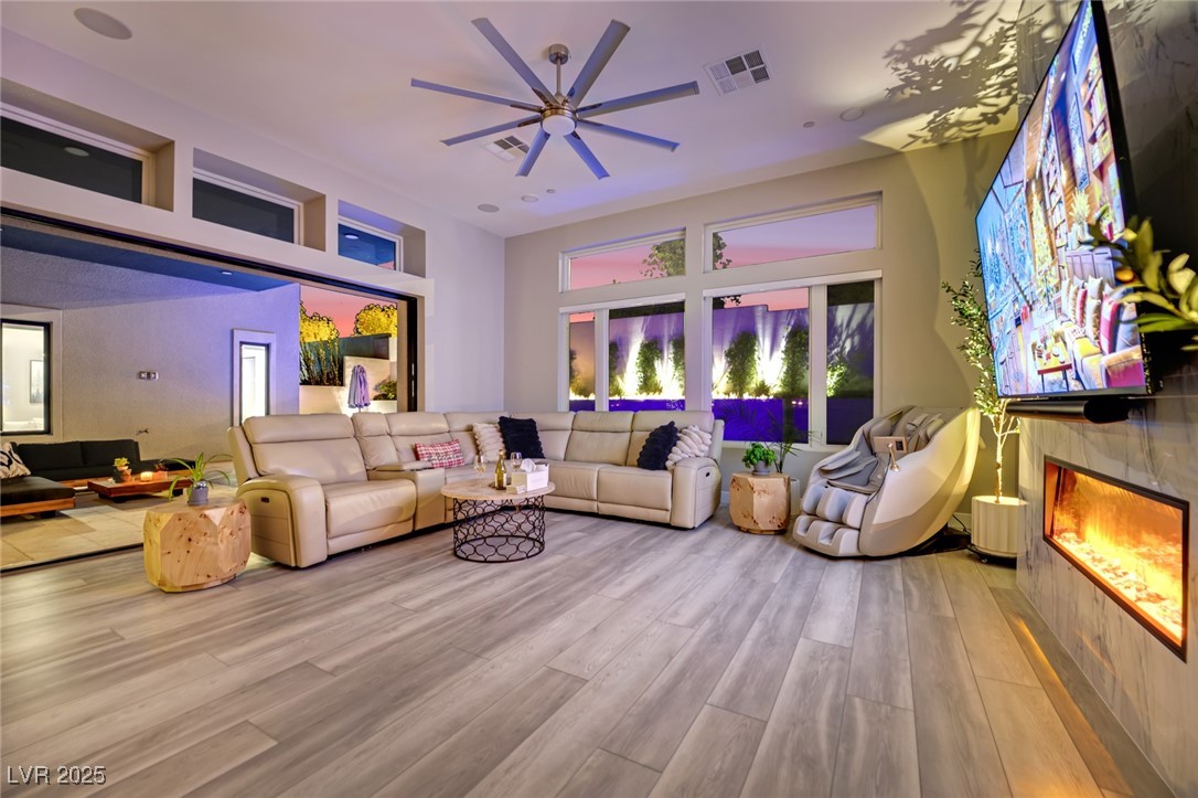 397 Highview Rdg Avenue Las Vegas, NV 89138 - Photo 28 of 97 Living area featuring a tiled fireplace, wood finished floors, and ceiling fan